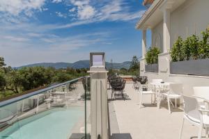 un balcone con tavolo, sedie e piscina di Nikon Boutique Hotel a Kalamákion