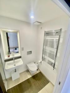 a white bathroom with a sink and a toilet at Amazing City Centre 1 bedroom Apartment with Balcony LGBTQ Friendly in Belfast