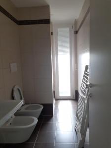 ein Badezimmer mit zwei Waschbecken und einem WC in der Unterkunft Avenir Apartment in Durrës
