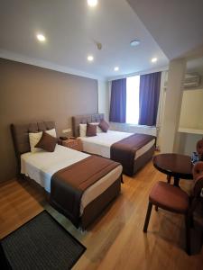 イスタンブールにあるホテル シルビアのベッド2台とテーブルが備わるホテルルームです。