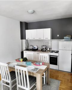 cocina con mesa de madera y electrodomésticos blancos en Cista DESETKA, en Požarevac