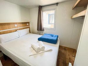 a bedroom with a bed with towels on it at Camping 3 Estrellas in Gavà