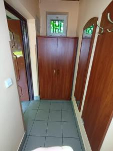 um corredor com portas de madeira e piso em azulejo em Lipowy Przylądek- Domek 12 