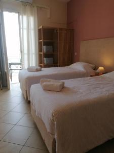 pokój hotelowy z 3 łóżkami i ręcznikami w obiekcie Ta Adelfia w mieście Pylos