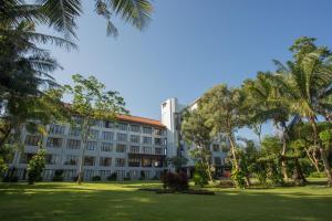 a building with palm trees in front of it at Bintang Flores Hotel in Labuan Bajo