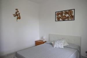 a bedroom with a bed and a picture on the wall at IL GIARDINO SELVATICO DI SUCCELLARIO - APARTMENTS in Ischia