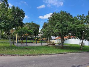 un parc avec une aire de jeux avec des toboggans et des arbres dans l'établissement Kitnets Aconchegantes Próximo ao Shopping, à Curitiba