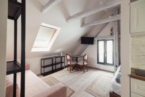 a room with a table and chairs and a window at Greatview Banensium Apartment in Banská Štiavnica