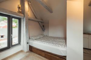 a small bedroom with a bed next to a window at Greatview Banensium Apartment in Banská Štiavnica +14 photos