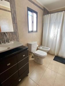 baño con aseo y lavabo y ventana en Apart Colon en Rufino