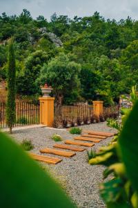 een rij houten banken in een tuin met een hek bij The Remote Hotel in Sarigerme