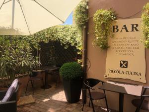博爾戈馬內羅的住宿－HOTEL DEL CORSO，一间带桌椅和遮阳伞的餐厅