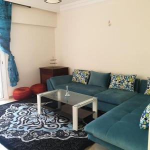 sala de estar con sofá azul y mesa en Appartement Neuf pour location, en Martil