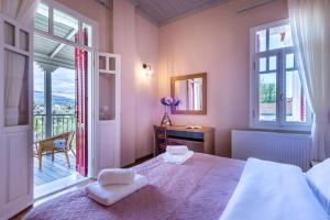 ein Schlafzimmer mit einem großen Bett und einem Balkon in der Unterkunft Sunset English Villas in Paralía