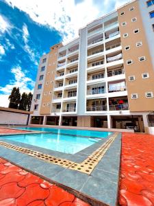 a swimming pool in front of a building at Nitro Homes Nyali in Mombasa