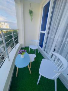 a balcony with two chairs and two tables at Nitro Homes Nyali in Mombasa
