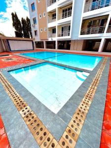 a large swimming pool in front of a building at Nitro Homes Nyali in Mombasa