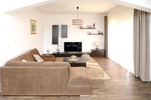 a living room with a couch and a tv at Apartments Adrian in Bibinje