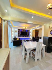 sala de estar con mesa blanca y sillas en Nitro Homes Nyali, en Mombasa