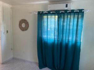 cortina de ducha azul en una habitación con puerta en SOFT YLaNG, en Dembeni