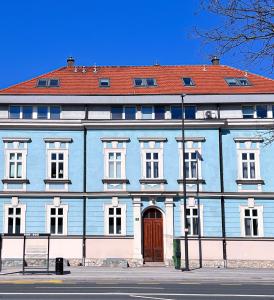 un grand bâtiment bleu avec un toit rouge dans l'établissement Apartment VIČ, à Ljubljana
