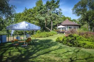 a garden with a table and chairs and a gazebo at Lipowy Przylądek- Domek 13 