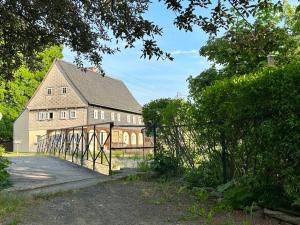 a large barn with a gate in front of it at Fewo Frushi mit Whirlpool, Infrarotsauna in Großschönau