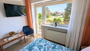 a bedroom with a bed and a window with a view at Dom nad Jeziorem in Szczedrzyk