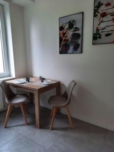 - une table en bois et 2 chaises dans une chambre dans l'établissement Apartament z widokiem na Rynek Kościuszki, à Białystok