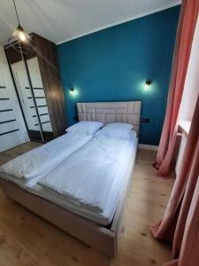 un grande letto in una stanza con una parete blu di Apartament z widokiem na Rynek Kościuszki a Białystok