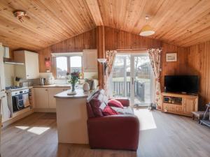 a living room with a couch and a kitchen at Oakwood 1 Pinewood Retreat in Lyme Regis