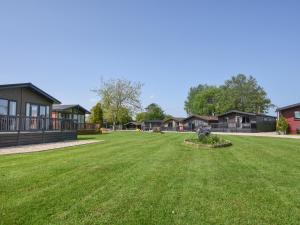 a large yard with houses in the background at Oakwood 1 Pinewood Retreat in Lyme Regis