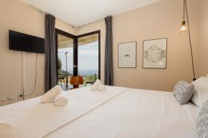 um quarto com uma grande cama branca e uma grande janela em Moderno apartamento vacacional con increbles vistas al mar con spa y gimnasio em Marbella