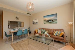 uma sala de estar com um sofá e uma mesa em Moderno apartamento vacacional con increbles vistas al mar con spa y gimnasio em Marbella