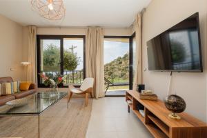 ein Wohnzimmer mit einem Sofa und einem Tisch in der Unterkunft Moderno apartamento vacacional con increbles vistas al mar con spa y gimnasio in Marbella