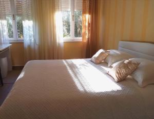 Apartment Puhov Zadar في زادار: غرفة نوم بسرير كبير عليها وسادتين