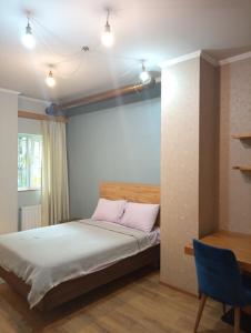 a bedroom with a bed and a desk and a table at M55 Home in Batumi