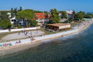 a group of people on a beach next to the water at Apartments Adrian in Bibinje