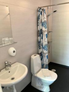 La salle de bains est pourvue de toilettes blanches et d'un lavabo. dans l'établissement Vättersmålen Stuga, à Gränna