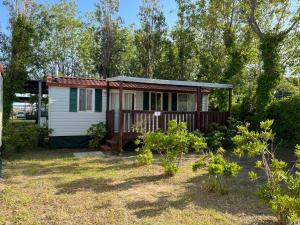 a tiny house with a porch in a yard at Sunny Beach Mobile Homes Rosapineta in Rosapineta