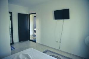 a bathroom with a sink and a tv on a wall at Casa Rebeka in Năvodari