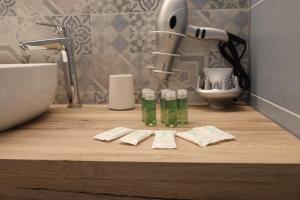 eine Badezimmertheke mit zwei Flaschen Seife und einem Waschbecken in der Unterkunft SUNSEA - Enjoy Your Family in Capo Vaticano