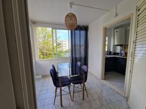einen Tisch und Stühle in einer Küche mit Fenster in der Unterkunft O'Lagon in Filaos + 4 Fotos