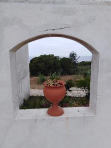 a vase sitting in a window with a vase at Alto da Praia Villa in Colares