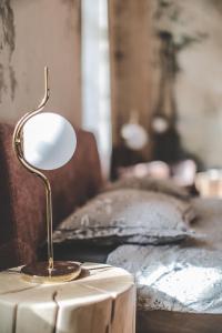 eine Lampe auf einem Tisch neben einem Bett in der Unterkunft Ruttner Suite in Veszprém