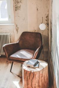 a chair and a table with a lamp on top of a tree stump at Ruttner Suite in Veszprém