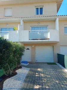 una casa con due porte garage e un balcone di Studio cosy a sainte marie la mer, Perpignan (66) a Sainte-Marie-la-Mer