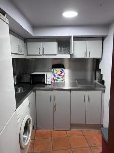 een kleine keuken met witte kasten en een wasmachine bij Cozy Duplex Príncipe Real in Lissabon