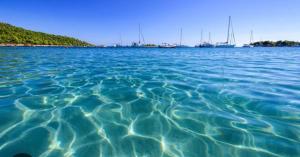 a large body of water with boats in the water at Camper Relax in Murter Slanica beach - with clima in Tisno
