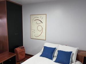 een slaapkamer met een bed met twee blauwe kussens bij Cozy Duplex Príncipe Real in Lissabon